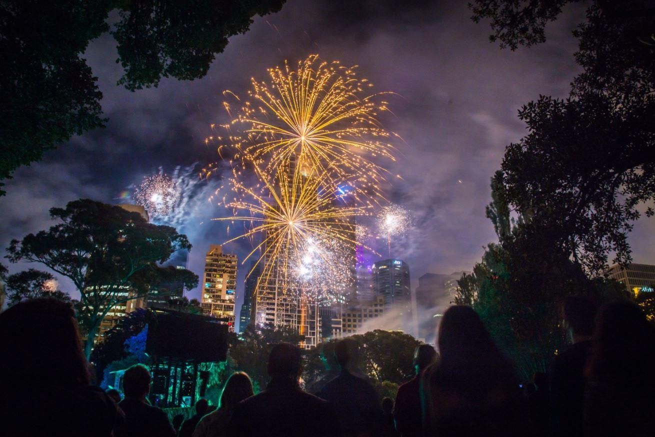 Люди наслаждаются семейным фейерверком в 9 вечера в канун Нового года в Сиднейской гавани